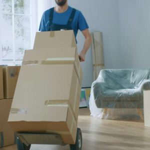 Professional Mover with Hand Truck Loads it With Cardboard Boxes and Helps People Move out and Relocate into the New House. Shot on RED EPIC-W 8K Helium Cinema Camera.
