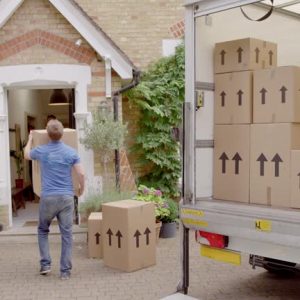 Movers unloading boxes from moving truck into new house. MS, real time.